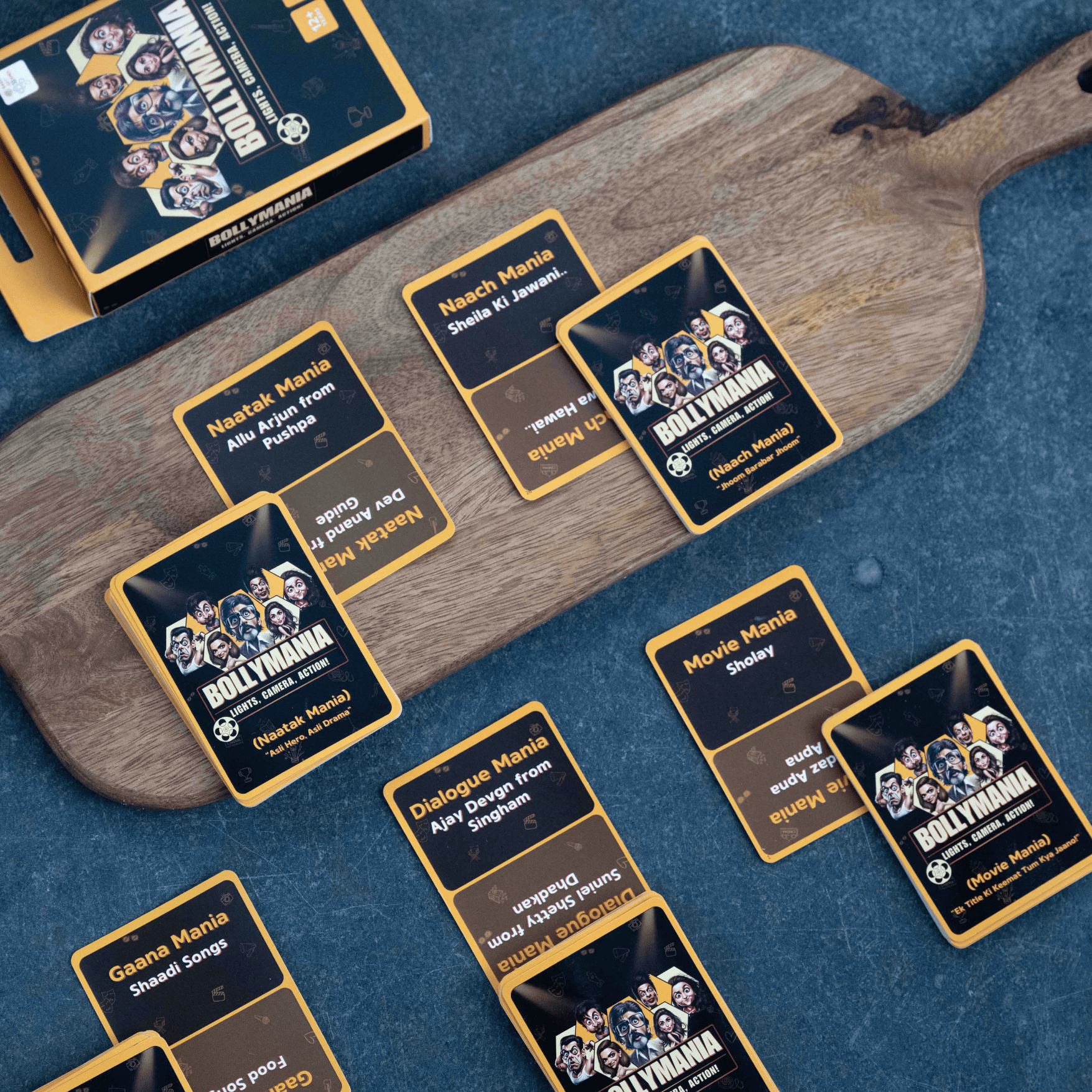 Group of friends playing Bollymania Bollywood card game at a party laughing and acting out Hindi cinema clues